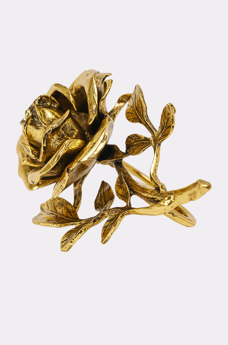 The IN BLOOM COCKTAIL RING features a gold-tone design shaped like a blooming rose with detailed petals and leaves, shown against a plain white background. 3