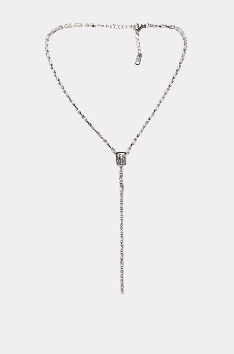 The I'M EXPENSIVE NECKLACE IN SILVER is a rhinestone lariat necklace with a central rectangular gemstone and a sparkling drop chain, showcased against a plain white background—an elegant statement piece for special occasions.