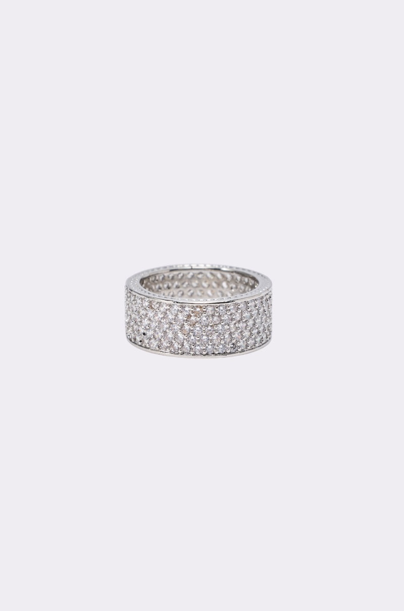 The TO INFINITY CZ RING is a wide silver-tone band encrusted with multiple rows of sparkling clear stones, shown against a plain light gray background. 0