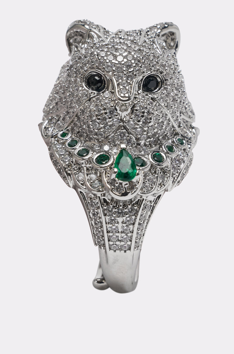 The LIFES A RUNWAY STATEMENT RING features a silver rhinestone cat’s head with black gemstone eyes and green gemstones on the neck—an unforgettable accessory.