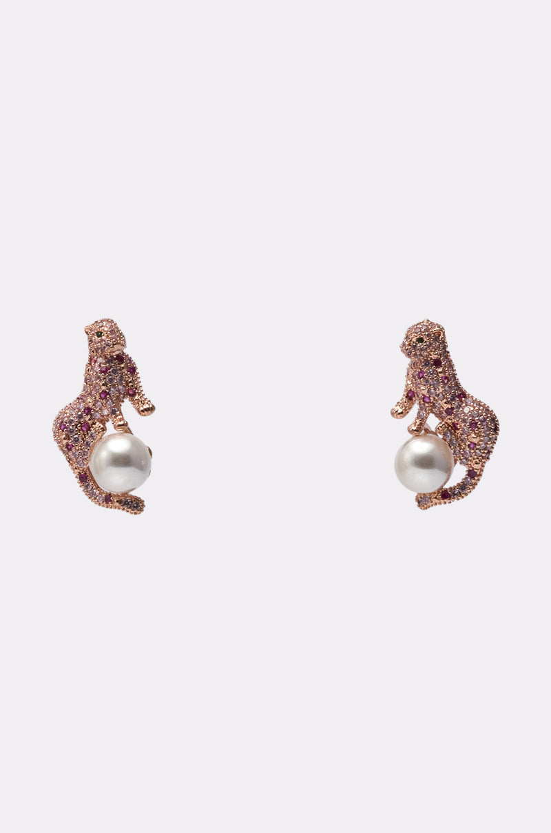 The LUXE PRIMETIME EARRING features leopard-shaped studs encrusted with pink stones, each holding a single round white pearl, displayed against a plain light background. 1