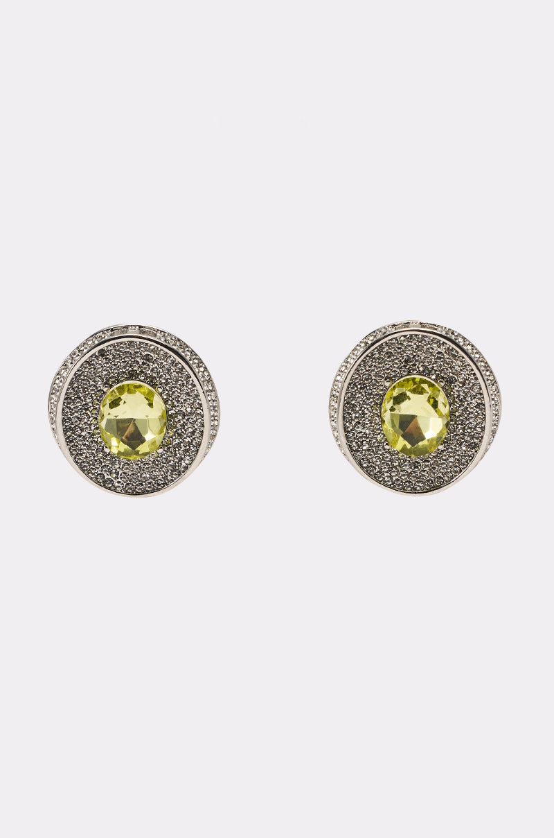 The RAY EARRING features a central yellow gemstone, rhinestone accents, and black textured concentric circles, displayed on a plain white background. 1