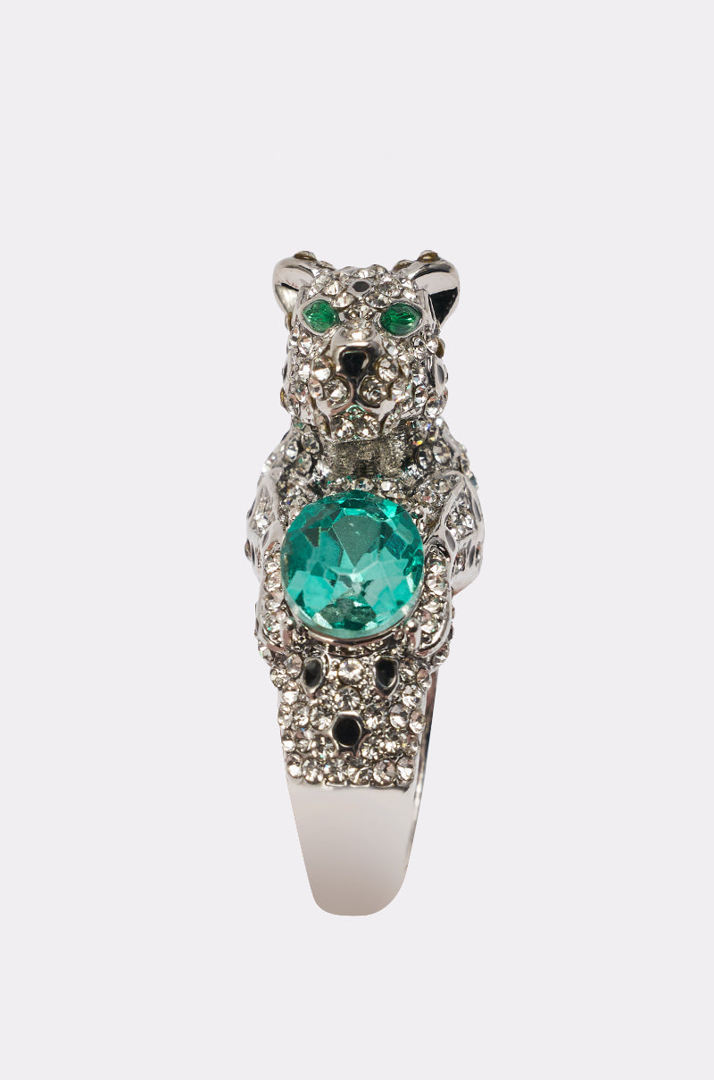The LUXE JAG RING features a silver-tone band shaped like a leopard, set with clear gems, striking emerald-green eyes, and a large round green stone held between its front paws. 4