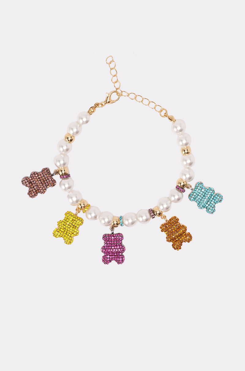 The LUXE BEAR CHARM BRACELET features five colorful bear charms—purple, yellow, pink, orange, and blue—on faux pearls. Displayed on a white background, this playful accessory adds vibrant elegance to any look. 0