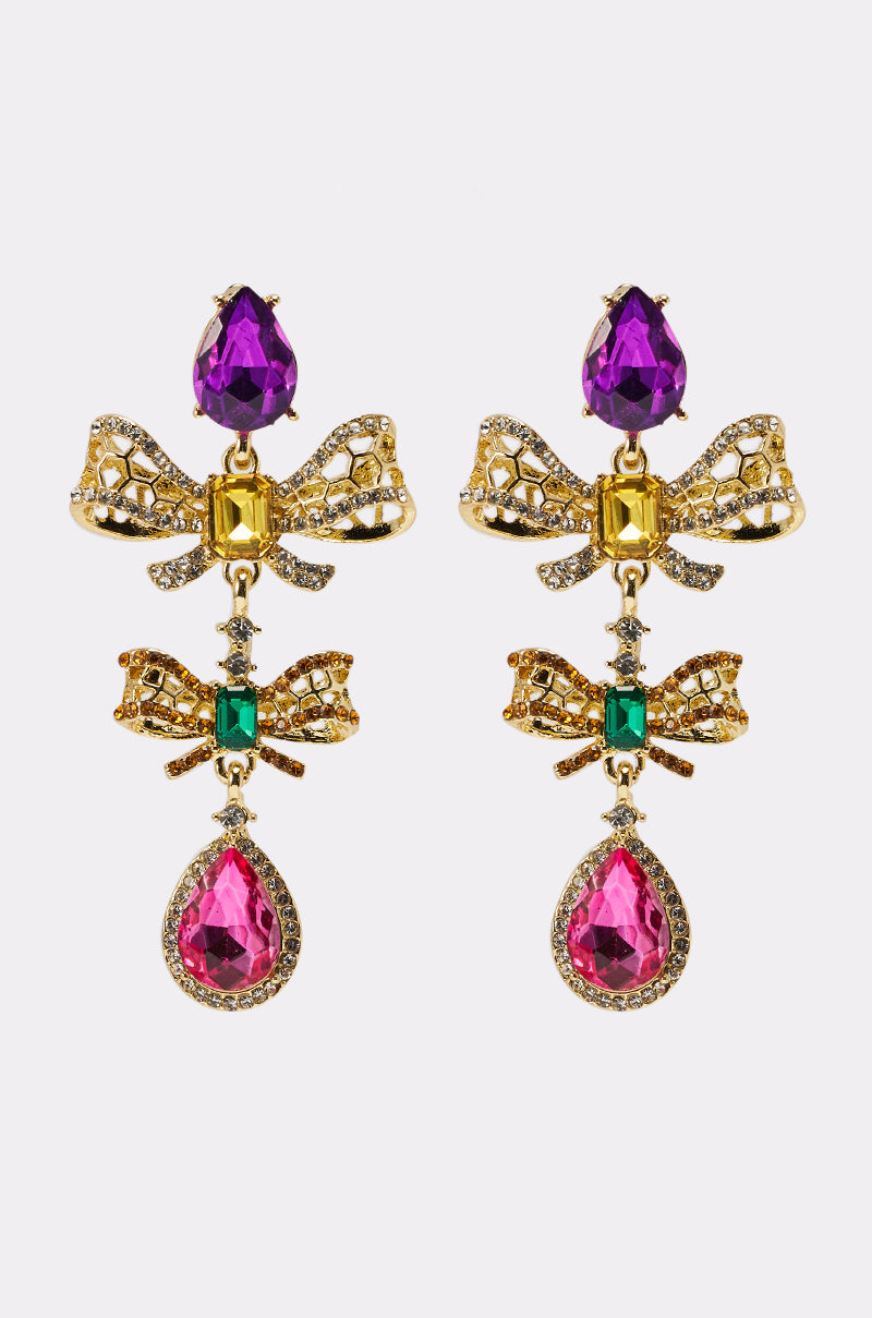The LUXE BOW EARRING features ornate gold teardrop gems in purple, green, and pink, intricate dragonfly designs, and crystal-encrusted bows for a dazzling effect. 1