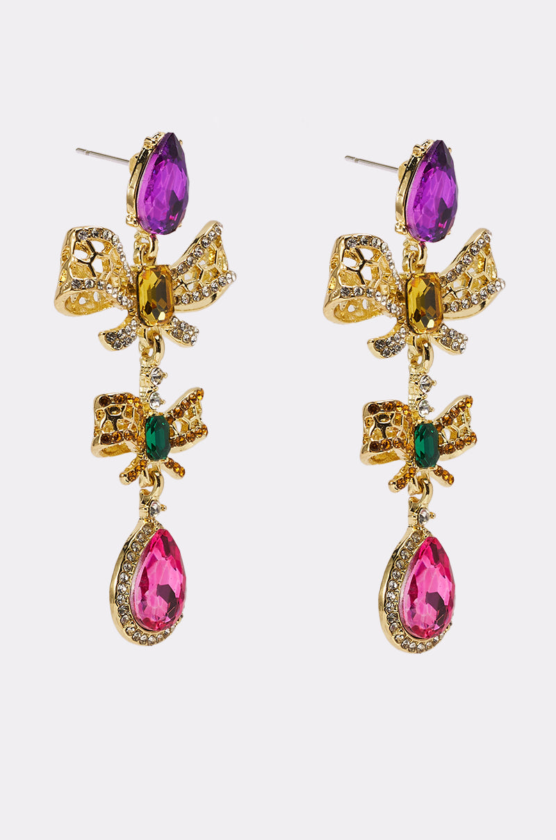 Elevate your style with the LUXE BOW EARRING—gold-colored, crystal-encrusted bows adorned with purple and pink teardrop gems and vibrant green, yellow, and pink stones. 2