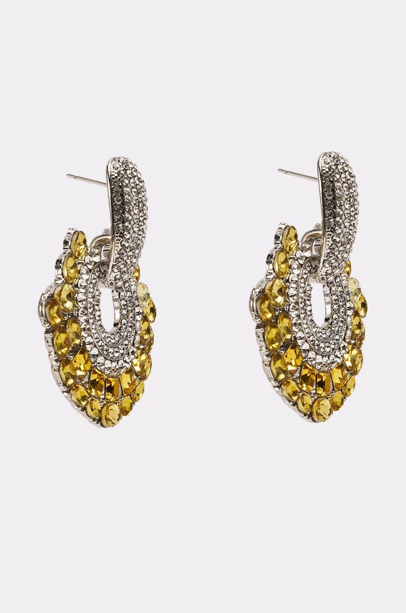 The LUXE TIS THE SEASON EARRING features ornate silver-tone ovals with sparkling crystals, clustered yellow stones, and rhinestone accents, presented on a white background. 2