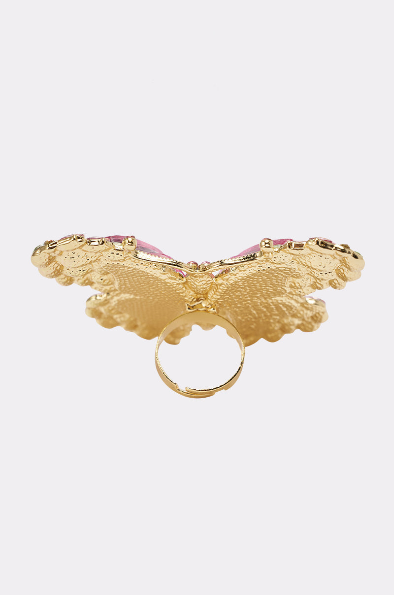 The SPREAD YOUR WINGS RING is a gold ring with a large, textured butterfly design and pink accents on the wings, shown on a light background. 9