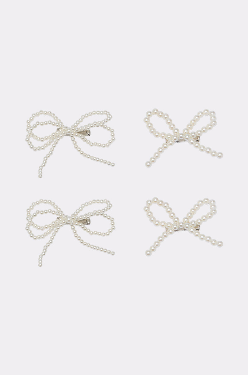 The POLLY PEARL HAIR CLIP SET features four uniquely shaped decorative bow clips crafted from small white faux pearls, arranged on a light background—perfect for adding charm and elegance to your hairstyle. 2