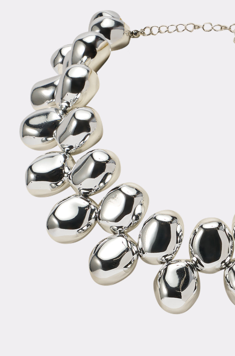 The CAME A LONG WAY NECKLACE showcases large, smooth pebble-shaped beads joined by small links and a delicate adjustable chain—an eye-catching silver statement piece for any occasion. 2