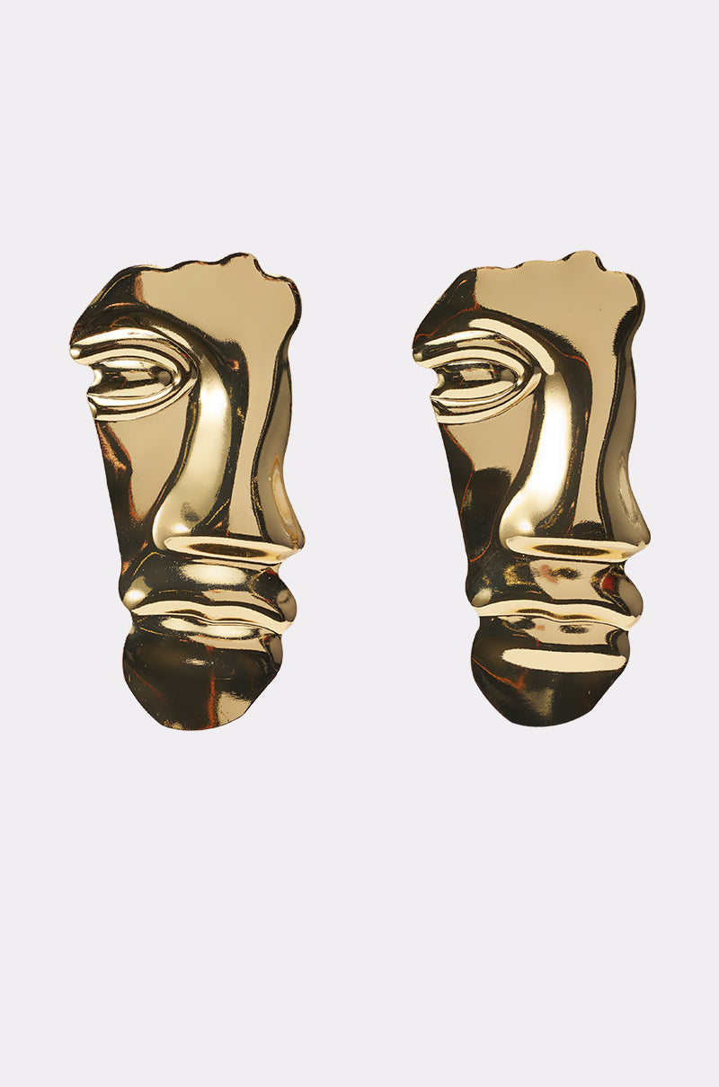 The 2FACE EARRING features a pair of gold-tone abstract earrings shaped like human faces with stylized details and smooth, shiny surfaces, displayed against a plain light background. 0