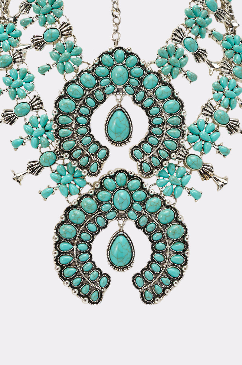 Make a statement with the HERE FOR THE VIBES NECKLACE—featuring bold turquoise crescent and teardrop stones, intricate silver details, and floral clusters. The perfect boho piece for your jewelry collection. 3