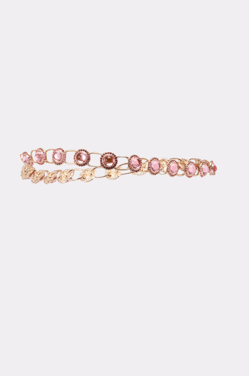 The ON A BOAT CHAIN BELT features a delicate gold band with pink gemstones in circular and oval patterns, resembling a gemstone chain, displayed on a white background. 2
