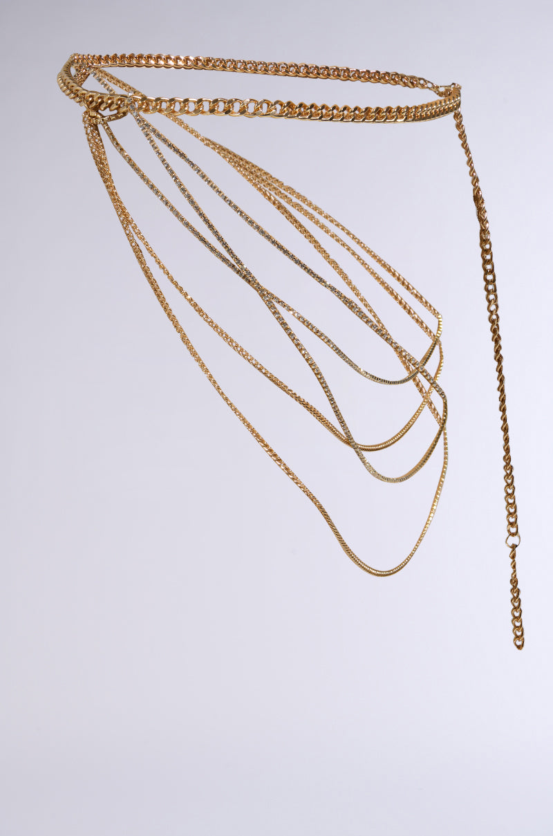 The CHAINZ 4 DAYS BELT IN GOLD, showcased on a plain gray background, boasts cascading strands and rhinestone links. Featuring varied chain sections for a layered and elegant aesthetic, this faux gold belt offers an adjustable fit. 3