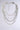 The TAKE A NOTE SILVER NECKLACE is a multi-layered piece with chunky silver chains in assorted link styles, accented by red, blue, and green gemstones, showcased on a light gray background.