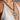 A person wearing a white beaded halter top and a chunky Cuban link chain with an oversized cross pendant, similar to the BIGGER IS BETTER NECKLACE.