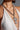 A person wearing a white beaded halter top and a chunky Cuban link chain with an oversized cross pendant, similar to the BIGGER IS BETTER NECKLACE.