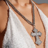 A person wearing a white beaded halter top and a chunky Cuban link chain with an oversized cross pendant, similar to the BIGGER IS BETTER NECKLACE.