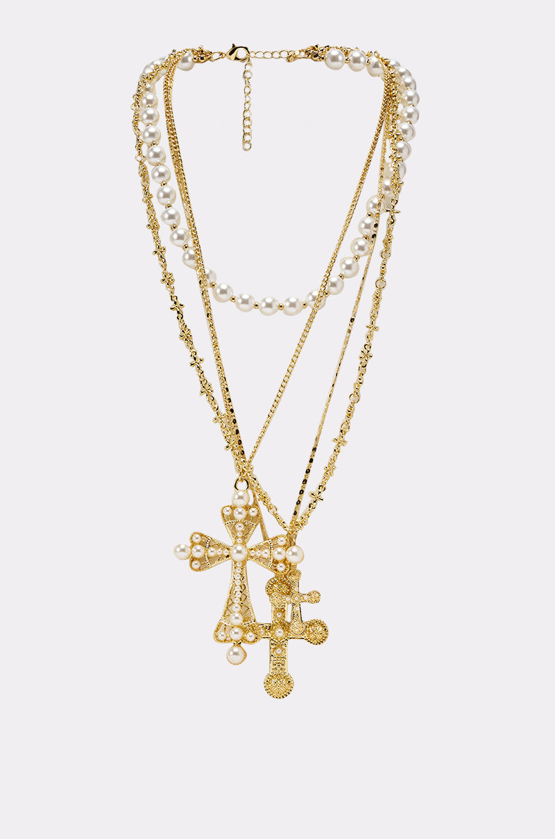 The SIERRA NECKLACE is a baroque-style piece with layered gold chains and faux pearls, highlighted by large ornate cross pendants adorned with pearls and textured accents. 1