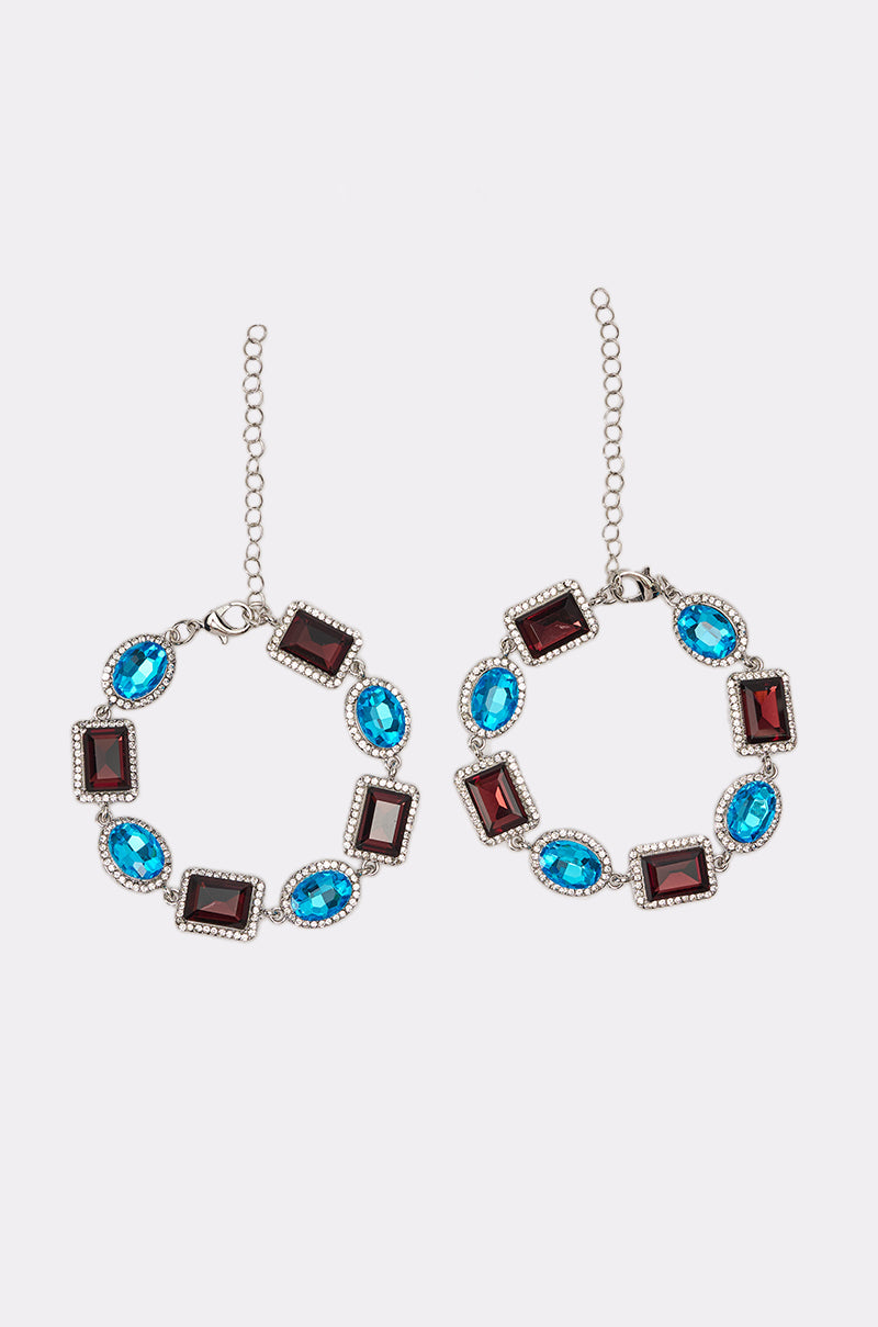 The CHOCOLATE WONDER BRACELET SET features alternating rectangular red gems and oval blue gems, each surrounded by small clear stones, beautifully displayed on a white background. 1