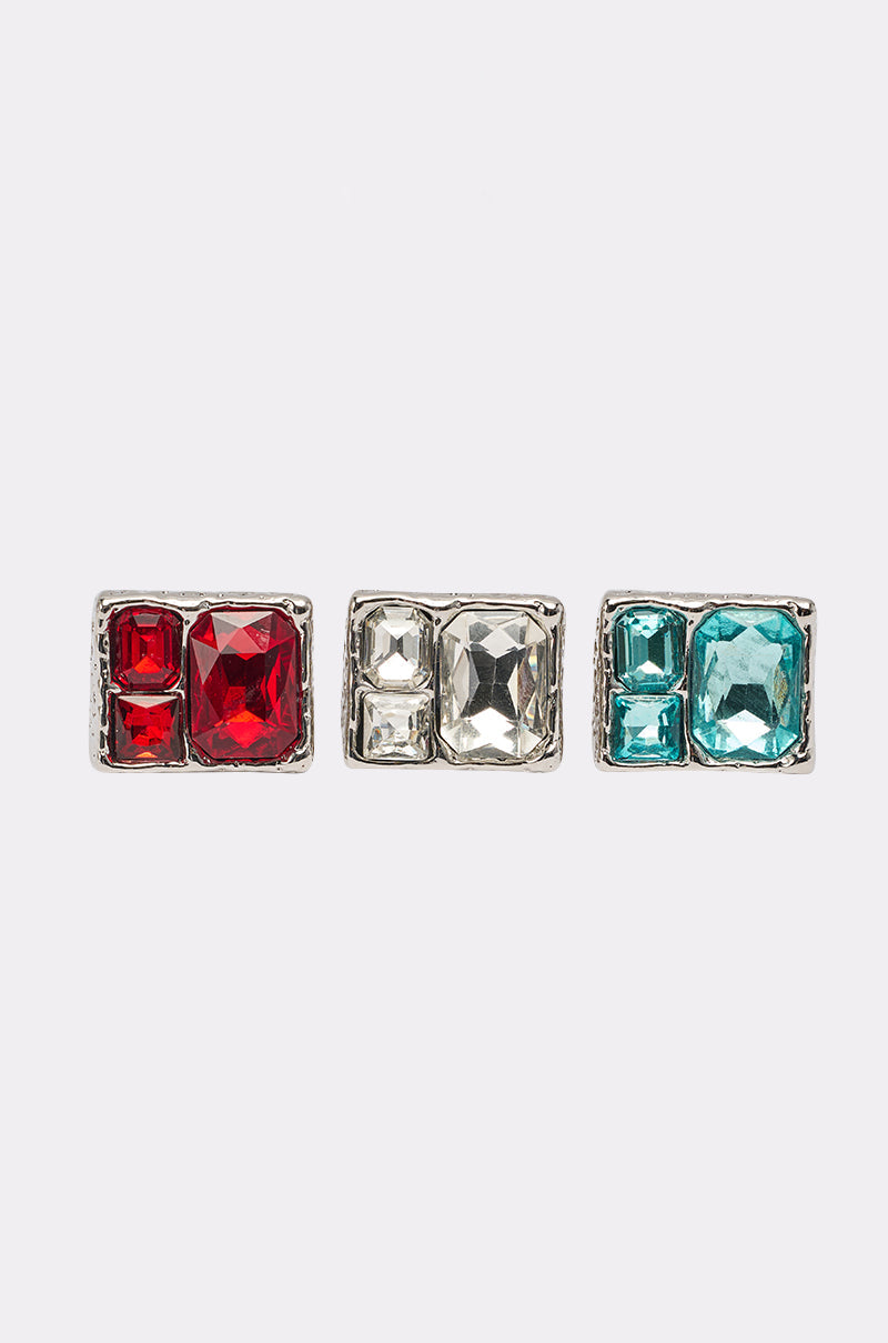 The FOR YOU RING SET includes three rectangular silver-tone pins, each featuring two square gems—one large and one small—in red, clear, and turquoise. Sleek and modern, they pair perfectly with geometric gemstone rings. Set against a plain white background. 2