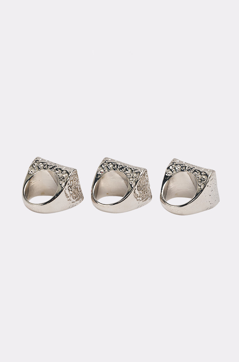 The FOR YOU RING SET features three chunky silver rings with textured sides and small geometric gemstones, elegantly arranged in a row on a plain white background. 3