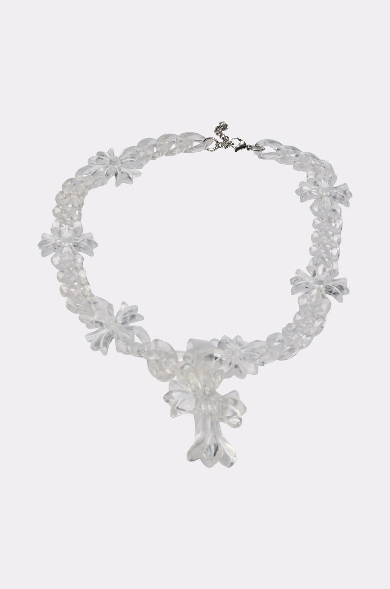 The CROSS ME CLEAR NECKLACE features flower-shaped beads and a bold cross pendant, making it ideal for statement jewelry lovers. Shown on a plain white background.