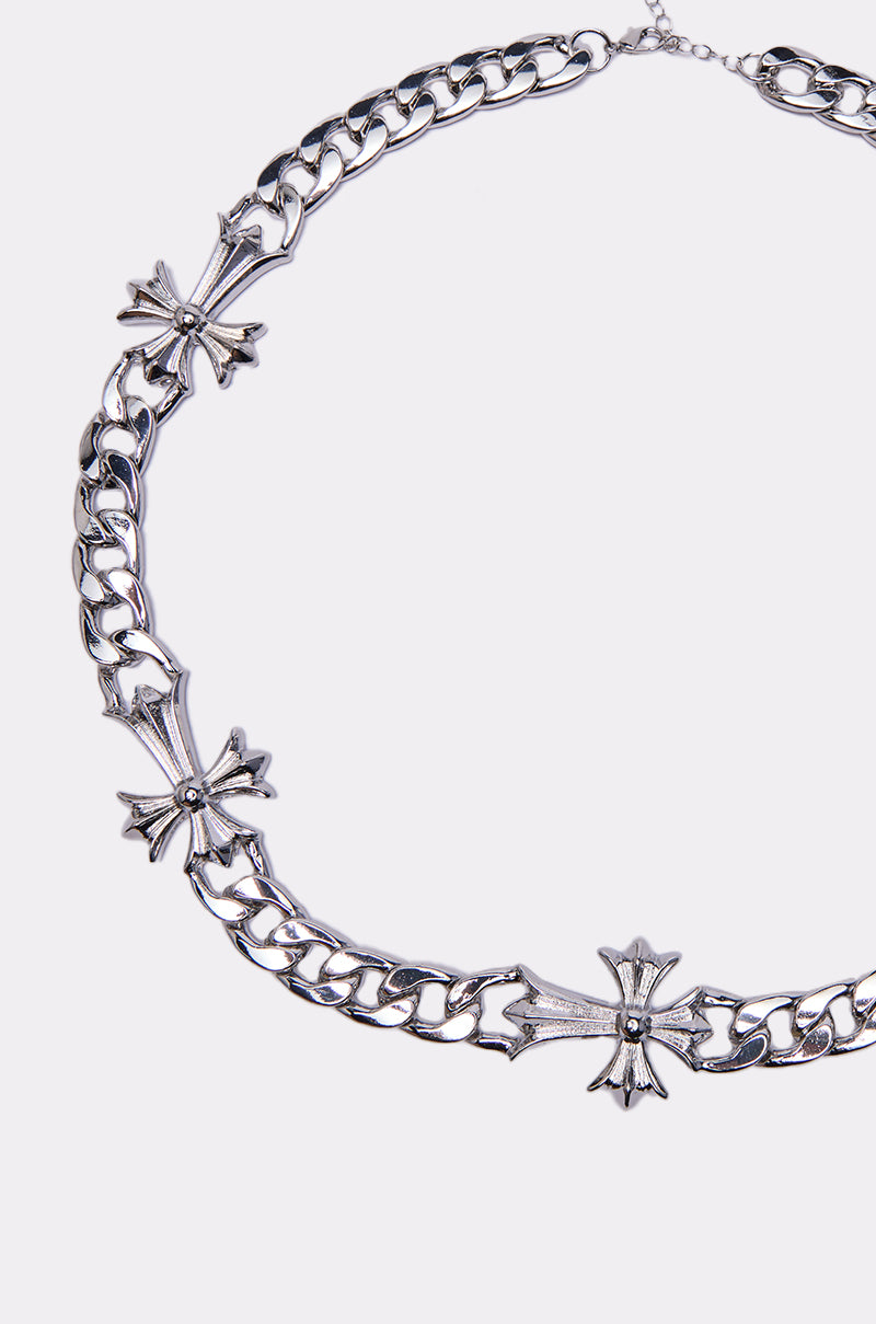 The ITS OFFICIAL NECKLACE is a chunky silver chain featuring three ornate cross designs spaced evenly along the length—an eye-catching statement accessory.