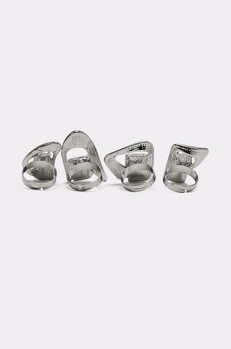 The TRUDY SILVER RING SET features four silver-tone rings with geometric shapes and textured surfaces, displayed in a row on a plain white background for a stylish addition to any collection. 5