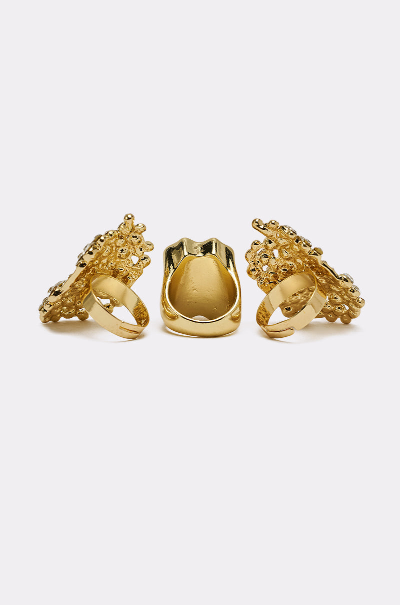 The CAN YOU NOT RING SET features three gold rings with textured, ornate detailing and sparkling crystal accents, displayed upright against a plain white background. 3