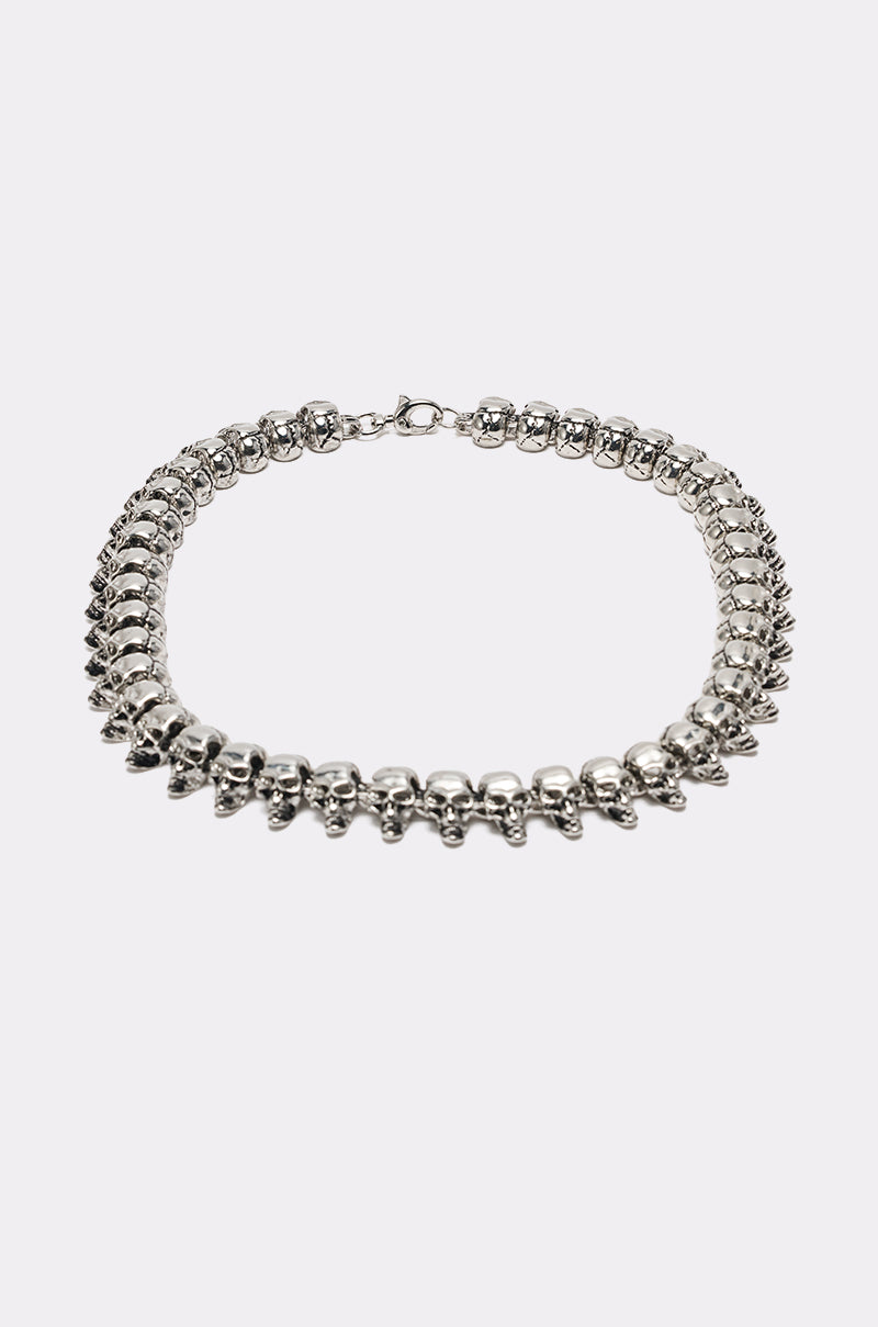 The SKULLY NECKLACE is a silver statement piece with small skull-shaped beads in a continuous loop, shown on a plain white background. 5