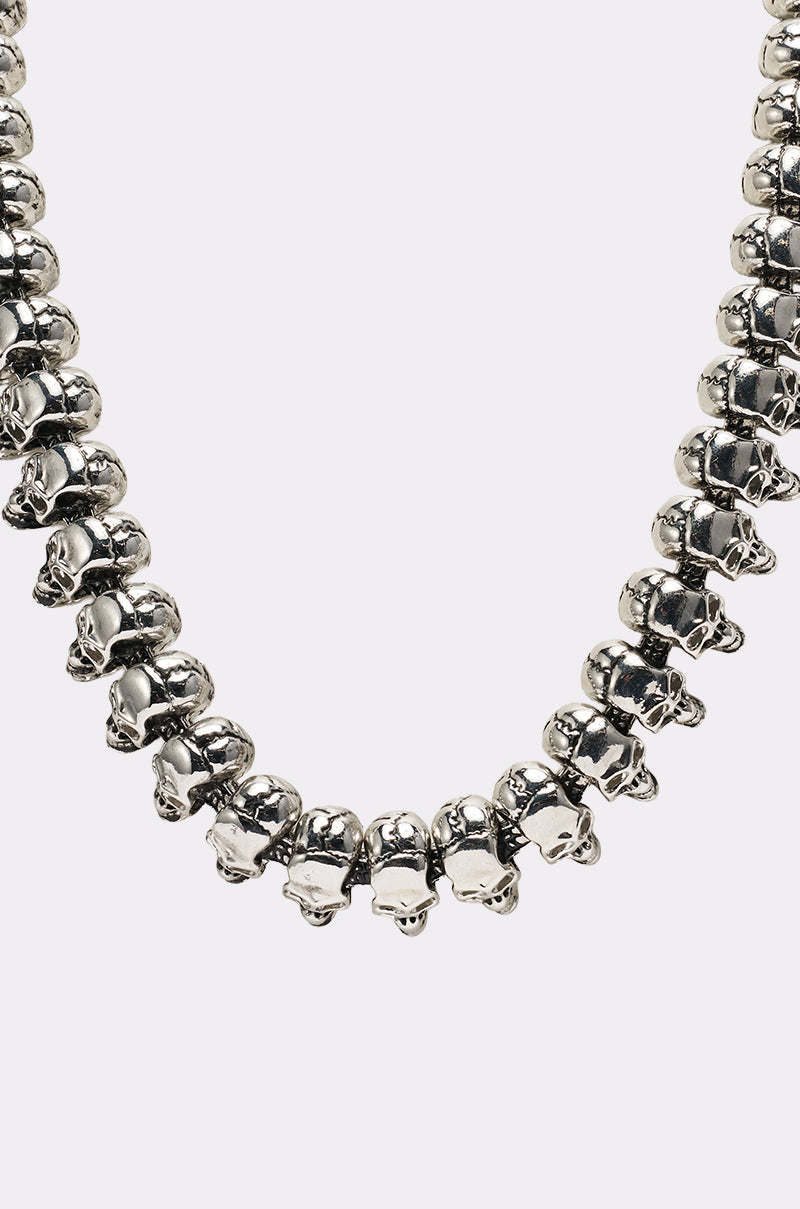 The SKULLY NECKLACE is shown in close-up, featuring silver skull-shaped beads linked together against a plain light background. 6