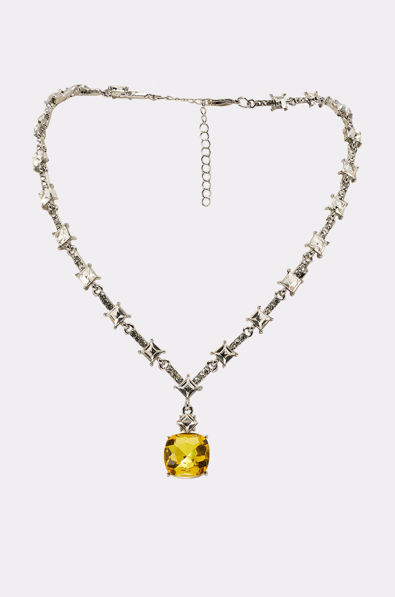 The LUXE KATE NECKLACE features star-shaped links and a crystal chain, highlighted by a bold square-cut yellow gemstone pendant at the center. 4
