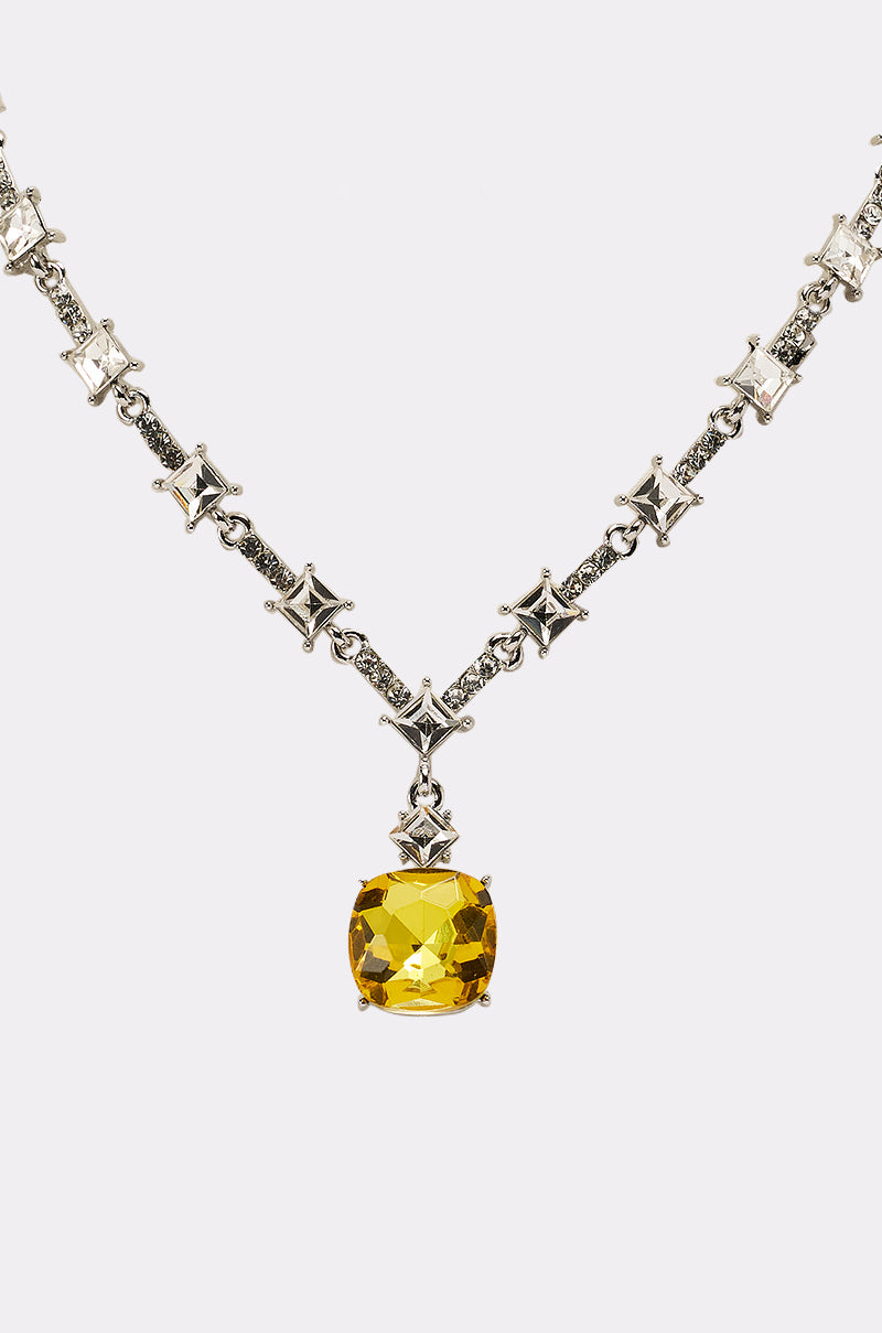 The LUXE KATE NECKLACE features star-shaped silver links and a large faceted yellow gemstone pendant, displayed on a plain white background. 6