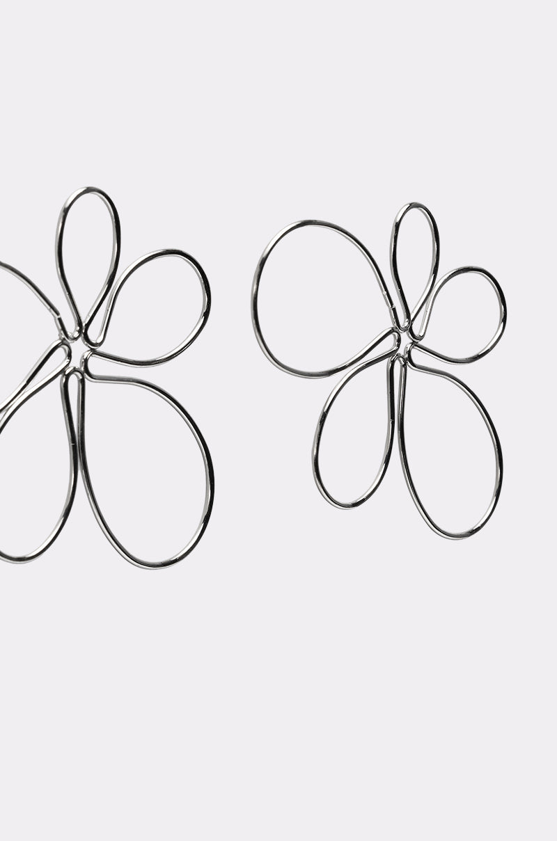 The LOVEY EARRING features two silver-tone wire earrings shaped like abstract five-petal flowers, shown on a plain light gray background. 4
