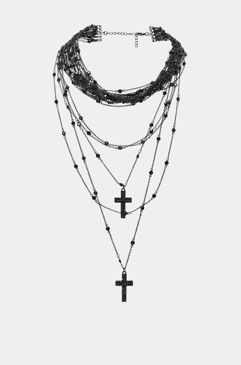 The DOLCE LAYERED NECKLACE features multiple chains, small beads, and three black cross pendants in a tiered design—perfect goth-inspired jewelry for bold, vampy statement looks.