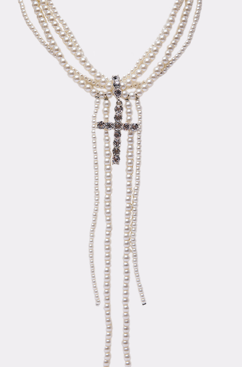 The CALL ME LATER PEARL NECKLACE showcases multiple pearl strands with a rhinestone cross pendant and cascading pearls at the center—an elegant statement jewelry piece. 2