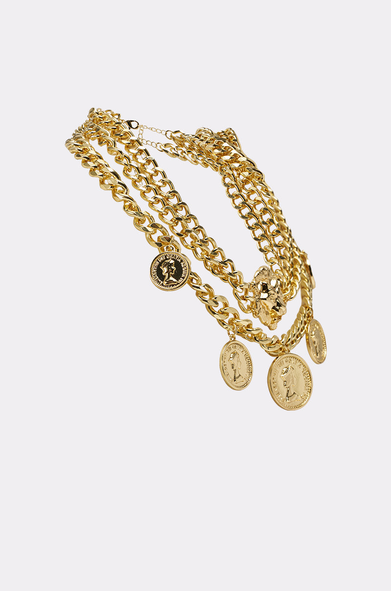 The AM WHO I THINK I AM NECKLACE is a statement layered coin necklace with multiple gold chains and coin pendants, elegantly showcased on a plain white background. 2