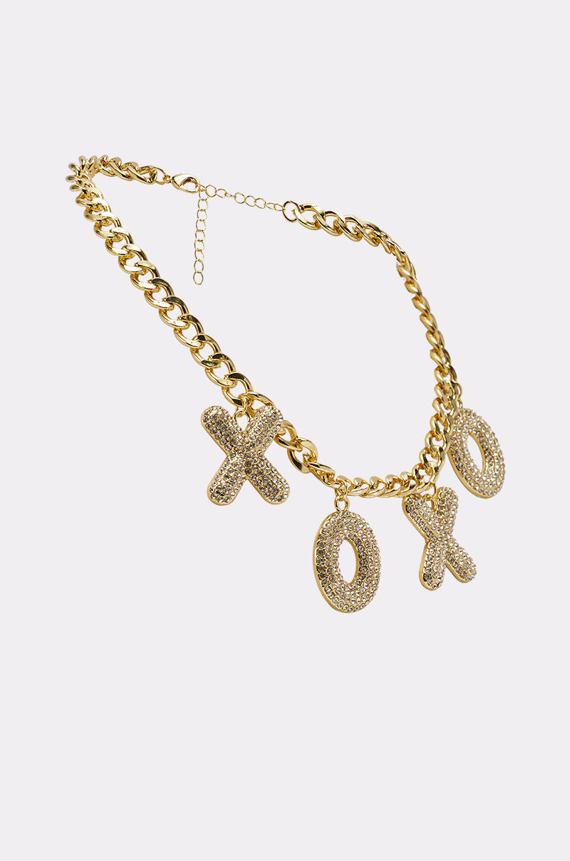 The KISSES NECKLACE is a chunky chain necklace with three large, rhinestone-encrusted XO letter charms, displayed against a plain white background. 4