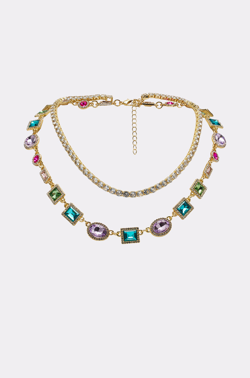 The RAY NECKLACE features gold-toned links accented with clear rhinestones and colorful square and oval gemstones—green, blue, purple, and pink—ideal for creating a bold layered necklace look. 0