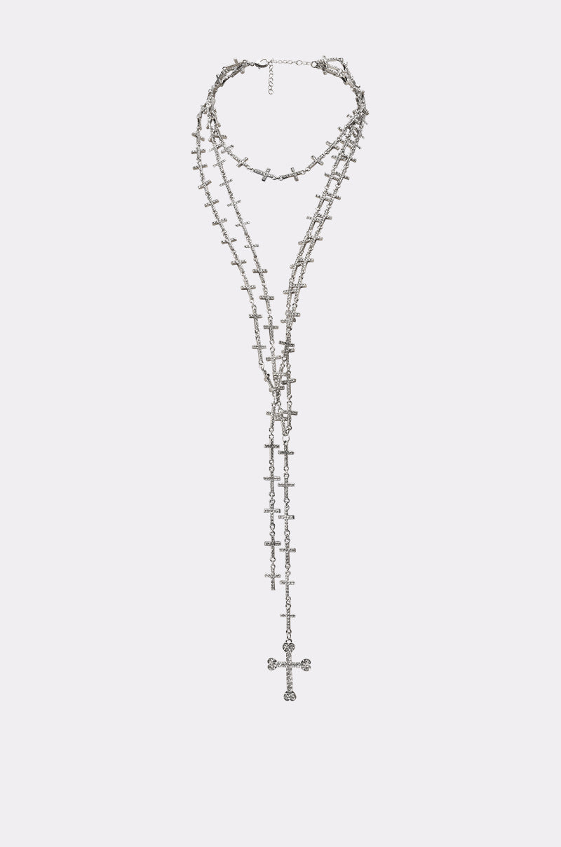 The TELL ME BOUT IT NECKLACE features layered silver multi-chains adorned with small cross pendants and a larger central cross, plus an adjustable clasp for the perfect fit. 0