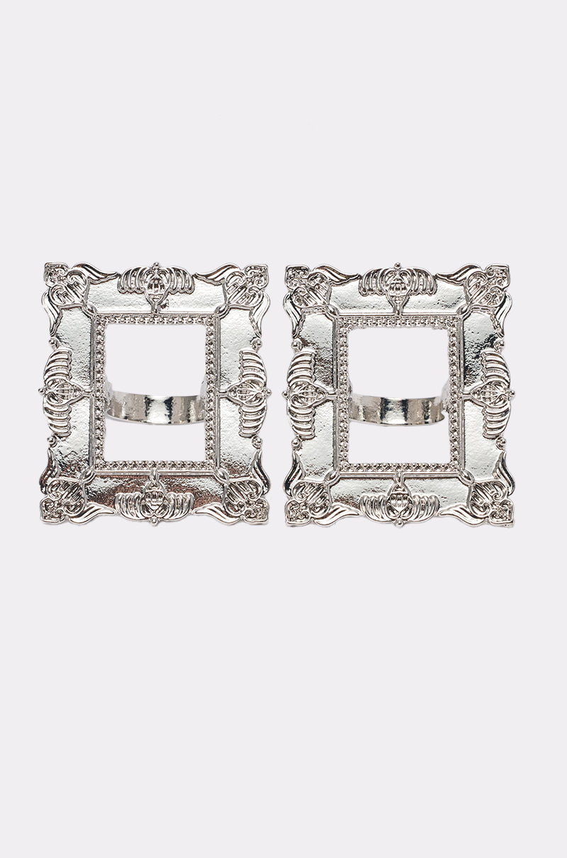 The FRAMED MIND COCKTAIL RING SET features two ornate metallic silver statement rings with open centers and decorative edges, resembling silver picture frames, displayed on a white background.