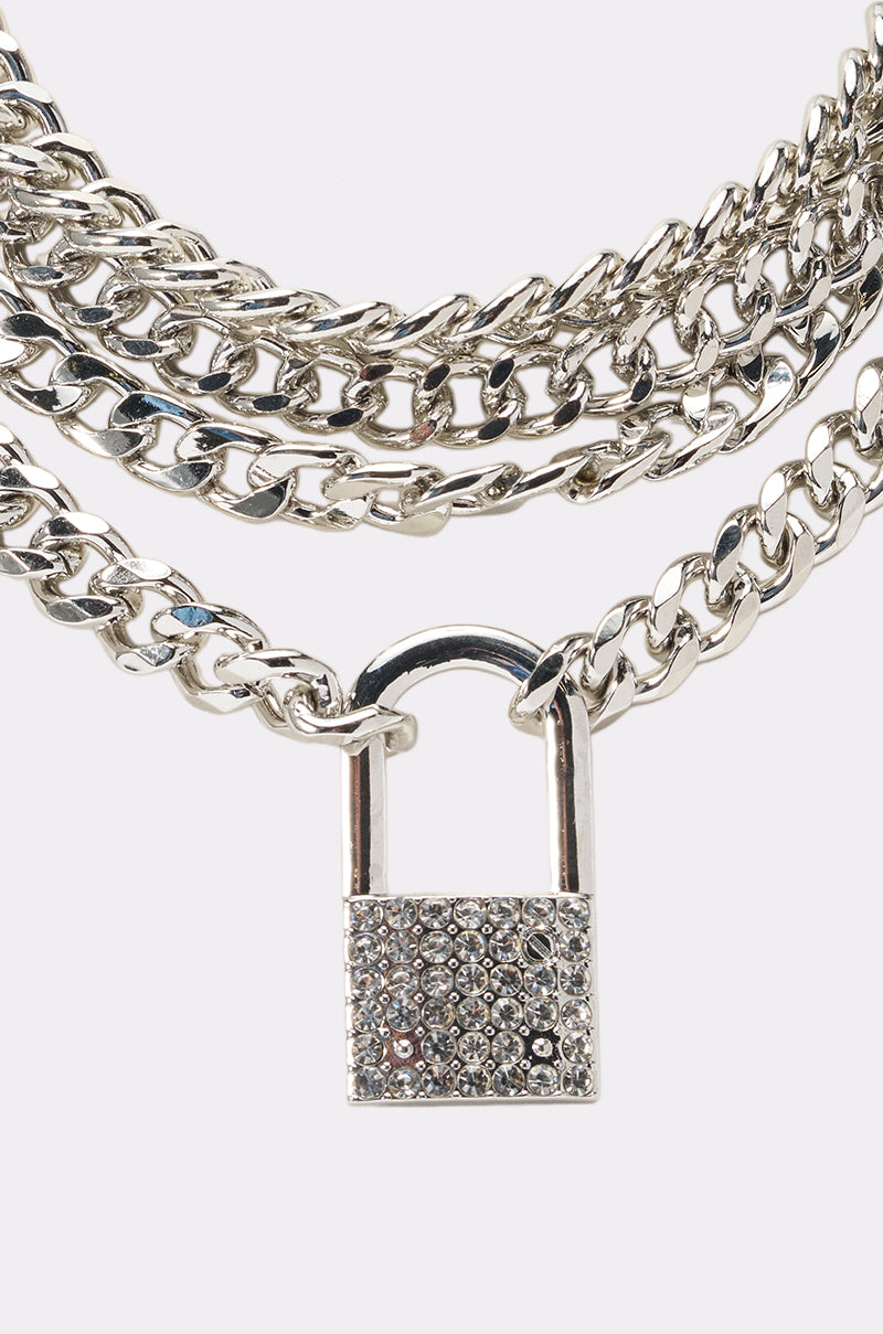 The KEEP IT ON LOCK NECKLACE is a multi-strand silver curb-link chain with a rhinestone-encrusted padlock pendant, making it the perfect statement piece for festivals. 1