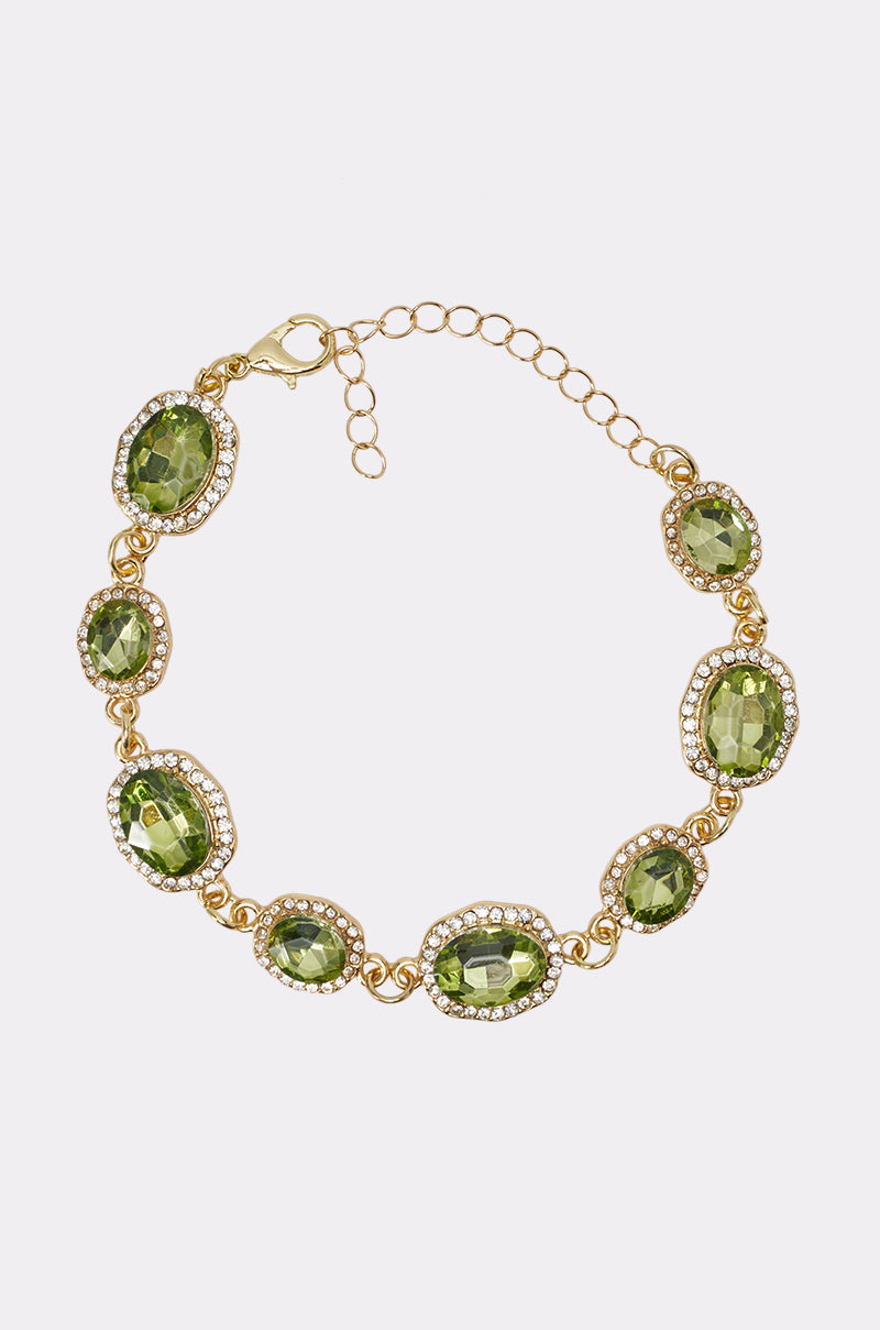 The EARL BRACELET features eight oval green gemstones accented by clear crystals, set in a gold-tone adjustable chain with a lobster clasp. This elegant rhinestone bracelet is the perfect summer accessory, shown on a plain white background.