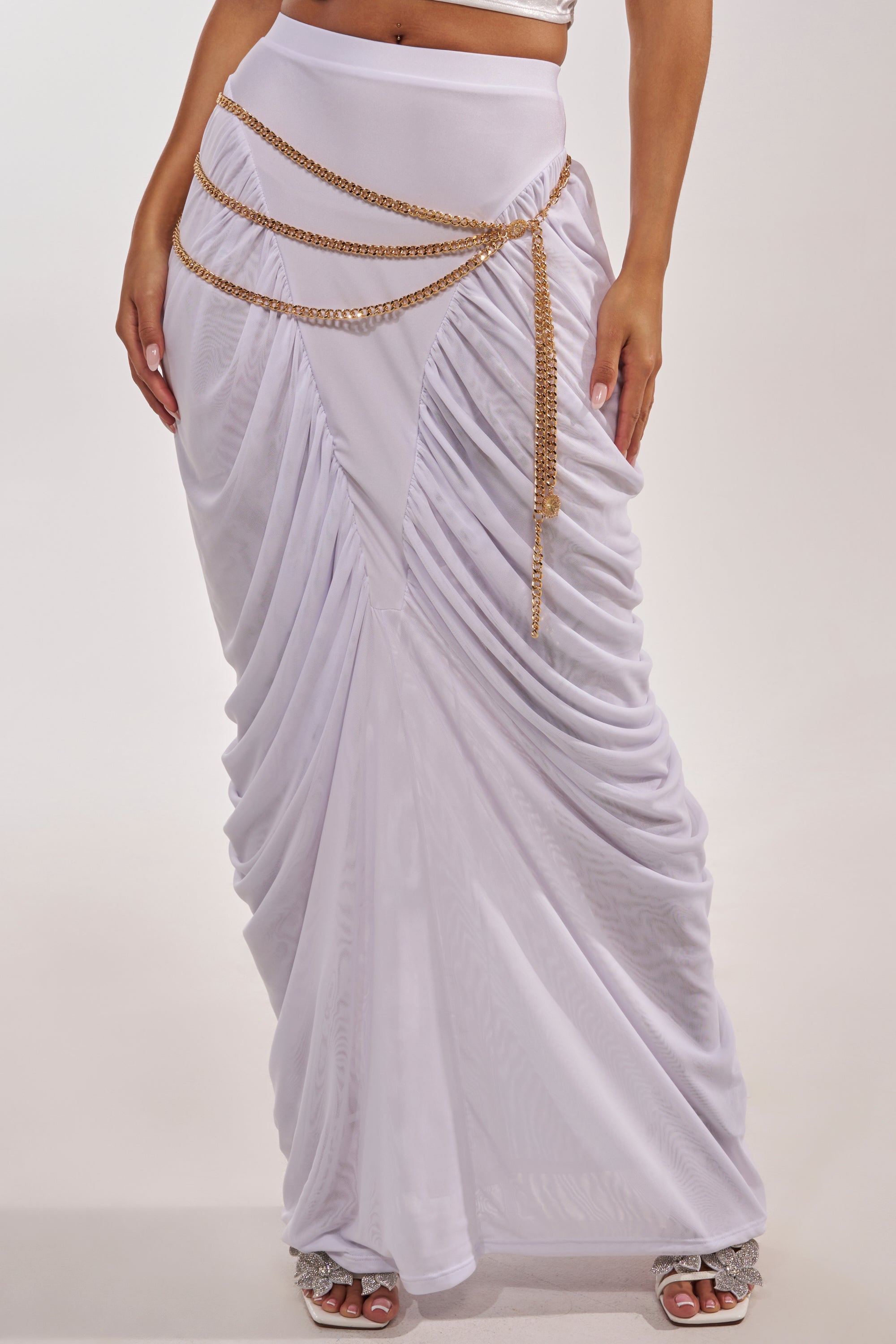 A person wears a white draped maxi skirt with the BUY ME DESIGNER CHAIN BELT at the waist and high-heeled sandals, creating a stylish, elegant look that makes the chain belt a standout accessory. 1