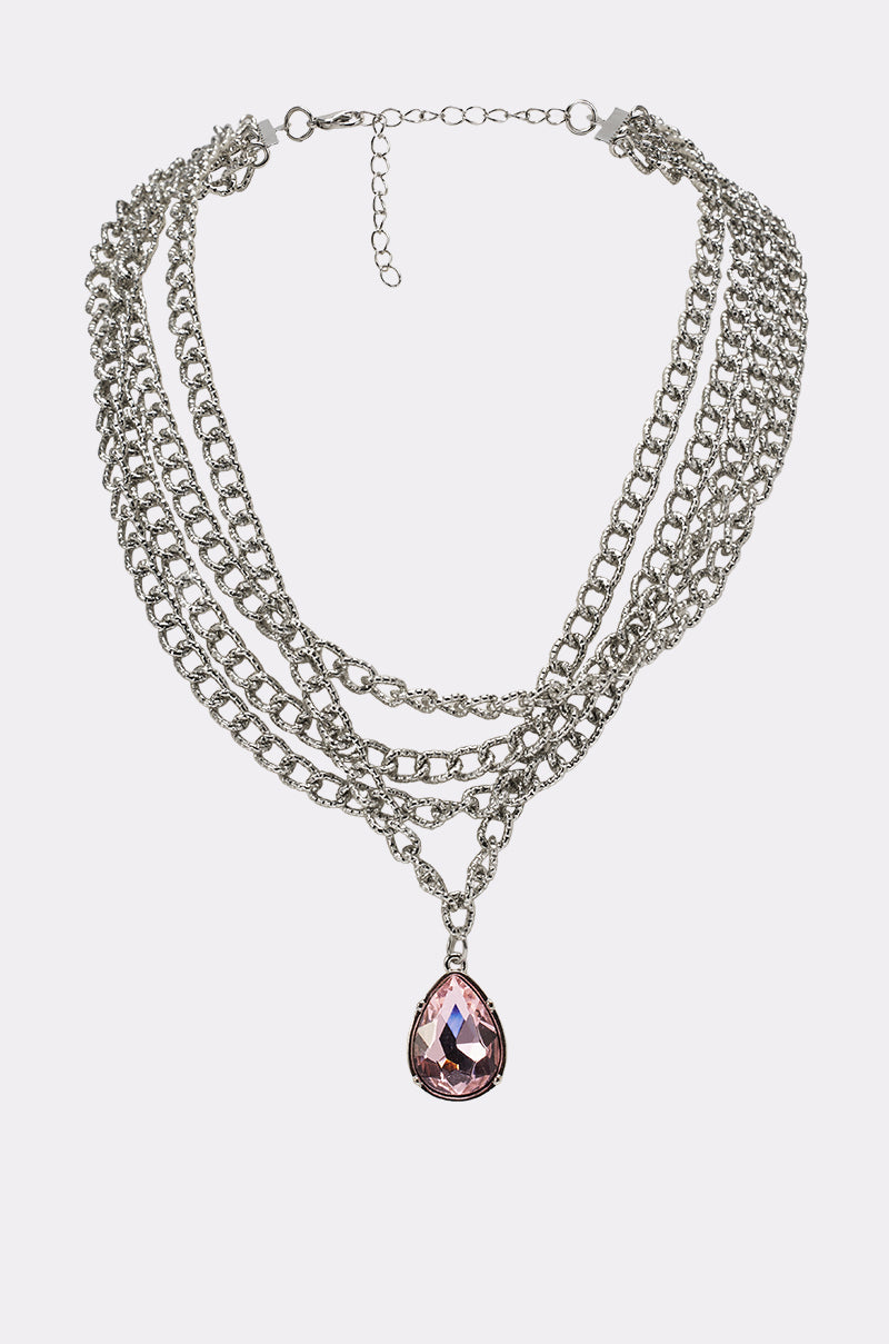 The PRINCESS TREATMENT NECKLACE features layered silver chains and a prominent pink teardrop pendant—perfect for making a bold crystal statement. 0