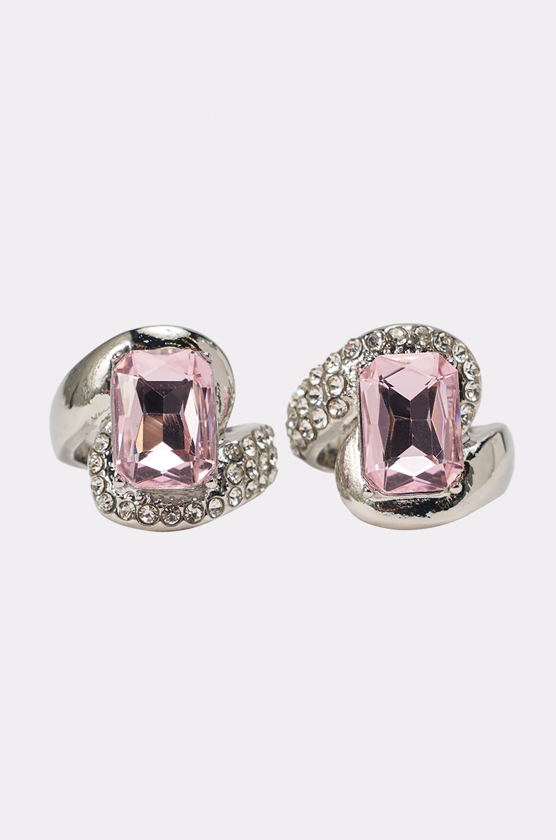The PRETTY IN PINK RING SET features chunky silver bands with large rectangular pink gemstones and rows of small clear crystals, shown on a white background. 1