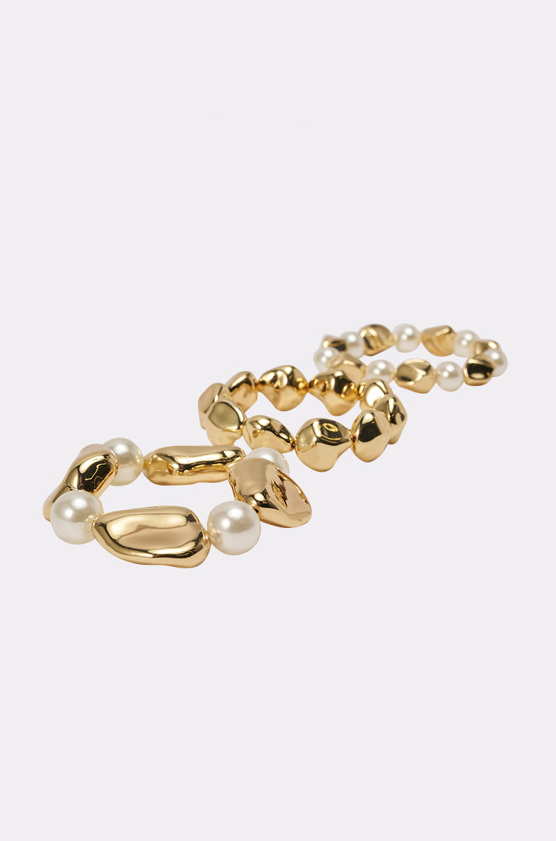 The STACK IT UP BRACELET SET features irregular, pebble-shaped gold links and round white pearls, shown on a plain white background—ideal as a chunky statement bracelet. 0