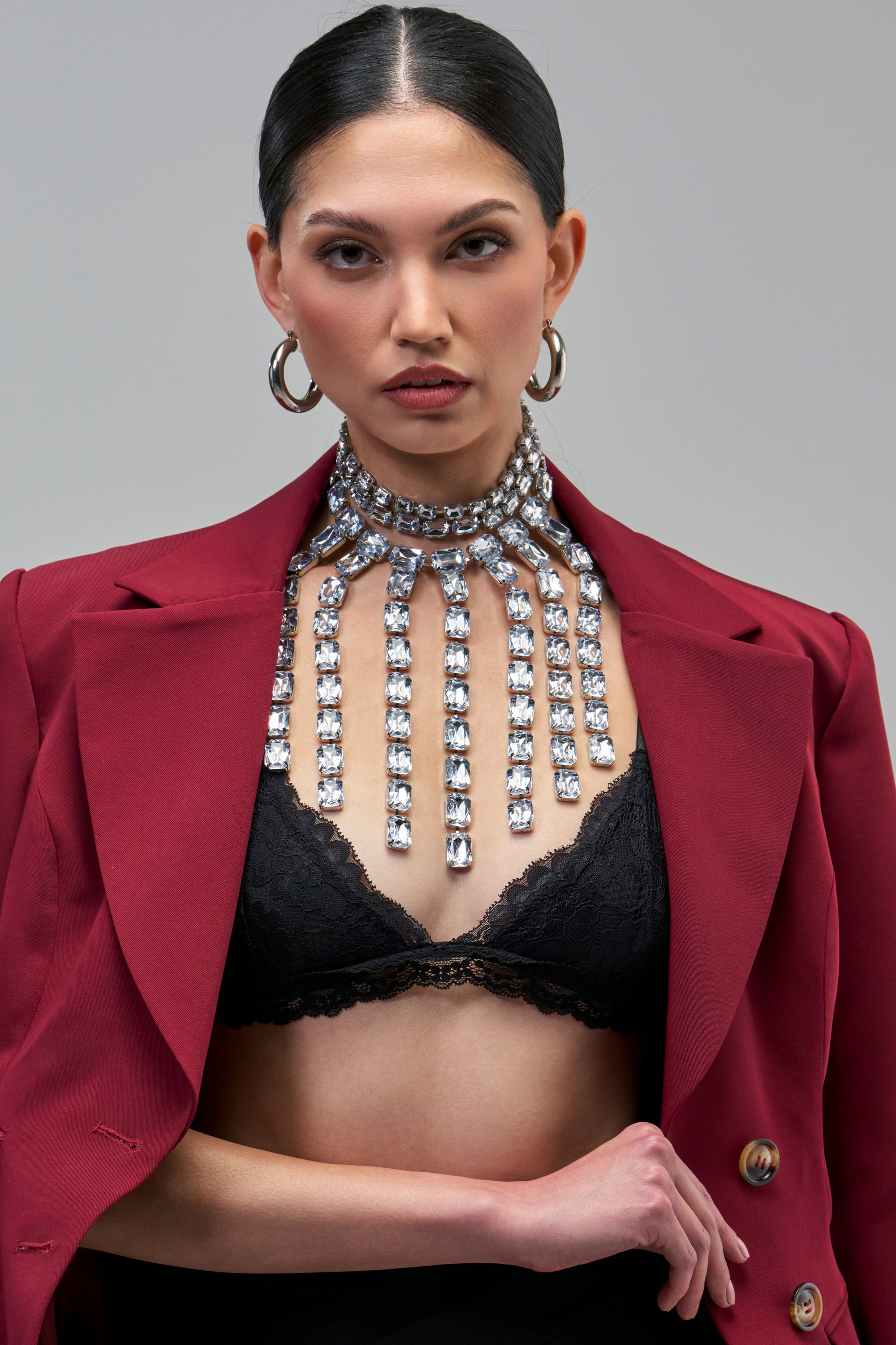 The ALL EYES ON ME NECKLACE is a silver statement piece featuring a high, crystal-embellished collar with vertical crystal-set fringe strands.