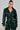 A person with long dark hair is wearing the stylish MONTE CARLO HOODED MOTO jacket and matching pants. The jacket, featuring a belted waist and deep V-neckline, enhances their look. Against a plain gray background, they exude confidence.